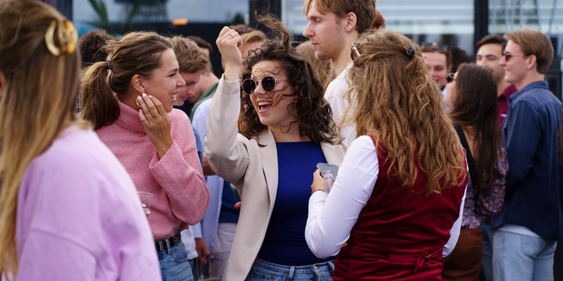 Categorie eventfotografie. Een jonge vrouw danst vrolijk in een menigte.