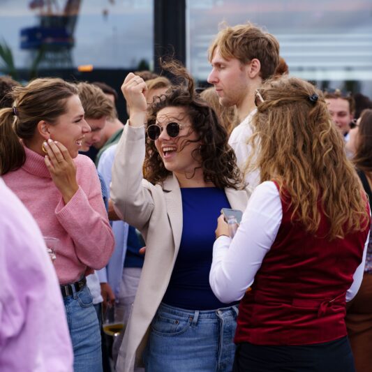 Categorie eventfotografie. Een jonge vrouw danst vrolijk in een menigte.