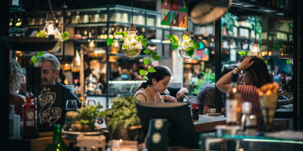 Categorie bedrijfsfotografie. Een vrouw zit in een druk bezocht winkelcentrum.