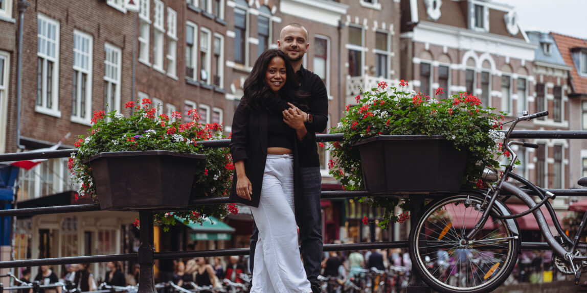Een pas verloofd stel poseert verliefd bij de Utrechtse grachten.