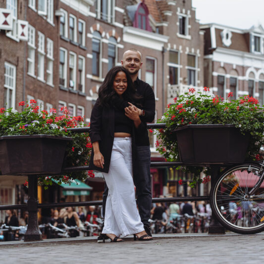 Een pas verloofd stel poseert verliefd bij de Utrechtse grachten.